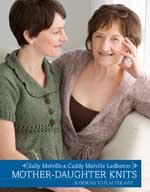 Two women sitting on a couch and smiling.