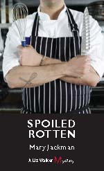 A person with an apron on and crossed arms.